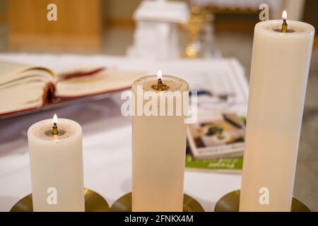 Baptism candles on church Altar during baptism Service Stock Photo