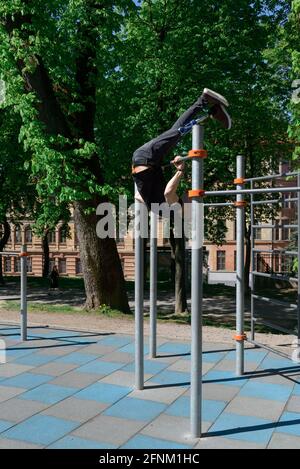 athletic young man with artificial leg working out on a bars Stock Photo