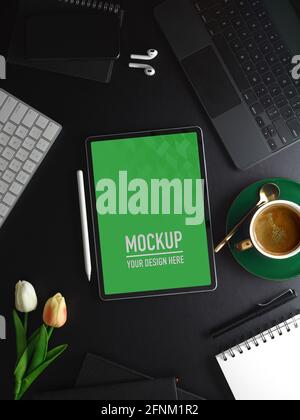 Top view of workspace with tablet, supplies, accessories and flowers decorated on black table, clipping path Stock Photo