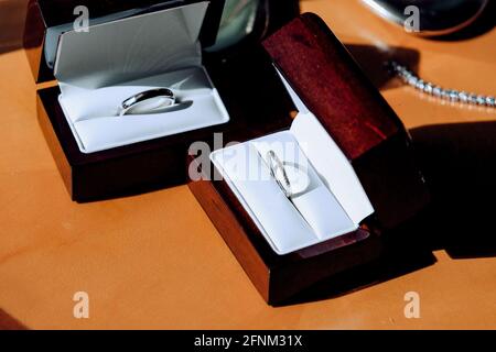 Wedding rings, made of white gold. Rings in 2 different boxes on the table. Stock Photo