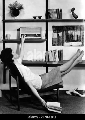 broadcast, radio, woman sitting in living-room and listening to the radio, circa 1960, ADDITIONAL-RIGHTS-CLEARANCE-INFO-NOT-AVAILABLE Stock Photo