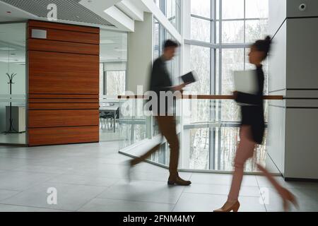 Blurred motion of business people walking along the office corridor Stock Photo