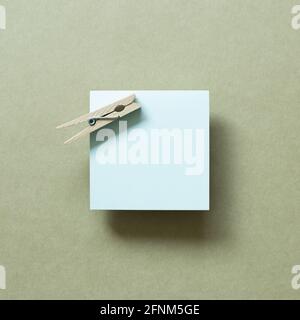 Blue memo pad with wooden clip on khaki background. top view, copy space Stock Photo