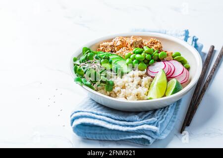 Vegan poke bowl with tofu, brown rice, beans and vegetables. Stock Photo