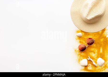 Beach accessories on sand with seashells, sraw hat and sun glasses Stock Photo