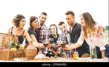 Young friends having fun outdoors drinking red wine at barbecue - Happy people eating healthy food at harvest time in farmhouse vineyard winery Stock Photo