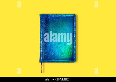 Neon Green and blue closed notebook mockup isolated on yellow background. Top view on mock up of notepad Stock Photo