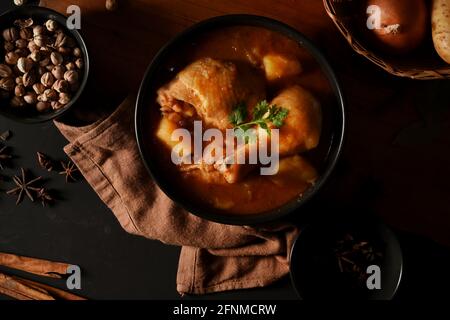 Top view of chicken Massaman Curry soup with ingredients on wooden table, Thai traditional food Stock Photo