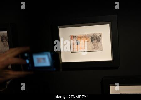 A person takes a photo of a Di-Faced Tenner at The Art of Banksy exhibition at 50 Earlham Street, London. Picture date: Tuesday May 18, 2021. Stock Photo