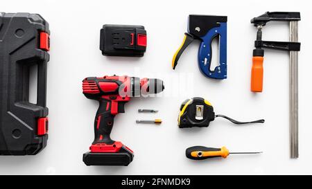 Set of various instruments on white background, top view. Tool case, electric drill, ruler and clamp tools, flat lay Stock Photo