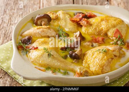 French food Coq au vin Riesling chicken in white wine with cream, bacon and mushrooms close-up in a saucepan on the table. horizontal Stock Photo