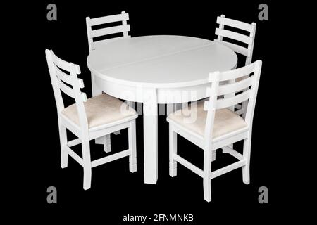 Elegant white table and chairs with clipping path. White table and chairs isolated on a black background. A set of furniture for lunch in the kitchen. Stock Photo