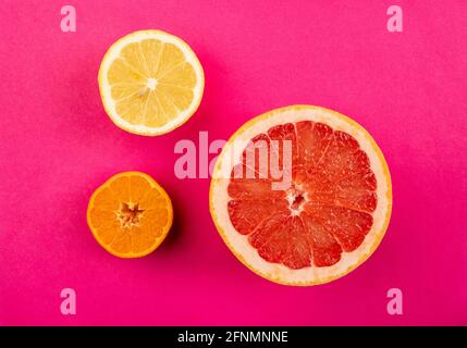 Citrus fruits slices isolated on pink background Stock Photo
