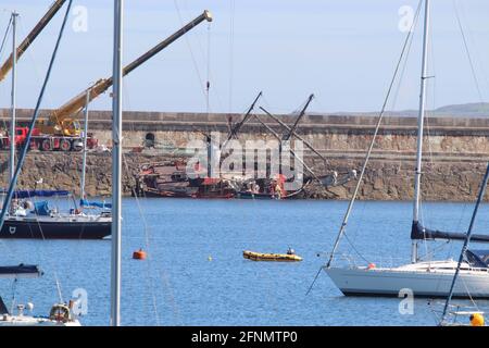 Holyhead , Anglesey, Wales  18 May 2021,The historic sail ship Zebu at a 45 degree angle against the breakwater at Holyhead marine, The historic tall sail ship Zebu had been heading to Bristol for conservation work from her home base at the Royal Albert Dock in Liverpool, attempts to refloat the tall sail ship are underway   Credit : Mike Clarke/Alamy Live News Stock Photo