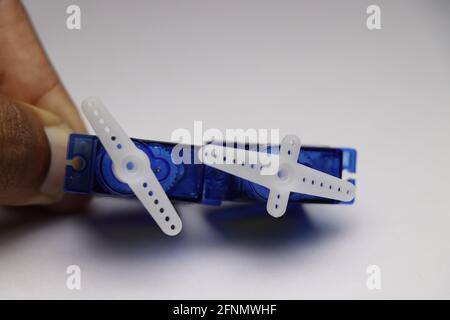 Pair of plastic geared micro servo motors held in hand which is controlled by micro controller use to make various hobby projects Stock Photo