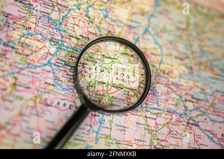 Close-up map of London through black magnifying glass, capital city in England, United Kingdom Stock Photo