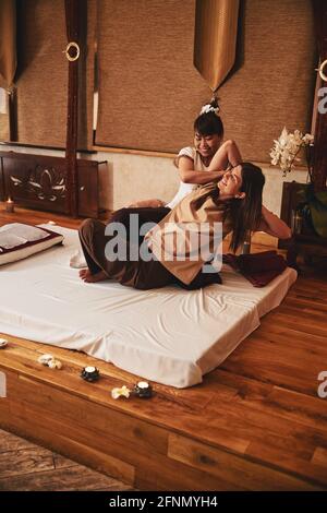 Thai yoga massage practitioner working on client arm muscles Stock Photo