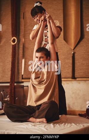 Both massagist and client enjoying Thai massage procedure Stock Photo