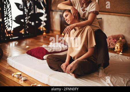 Massage professional tilting female client head to right Stock Photo