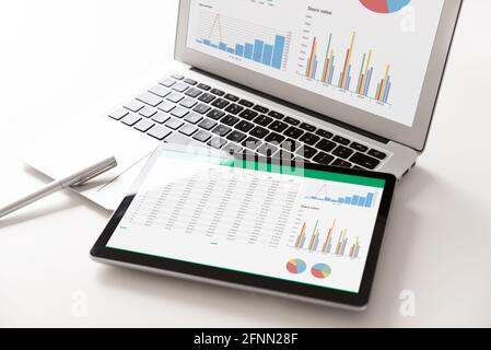 Business analytics applications on tablet and laptop. Financial data analysis concept Stock Photo