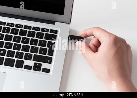 Hand connecting USB flash drive. Pendrive, flash memory concept Stock Photo