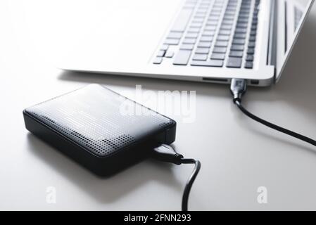 External USB disk, hard disk drive connected to laptop Stock Photo