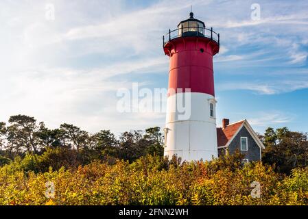 Historic white and red lighthouse under cloudy sky with patches of blue at sunset. Nauset lighthouse, Cape Cod  National Seashore. Stock Photo