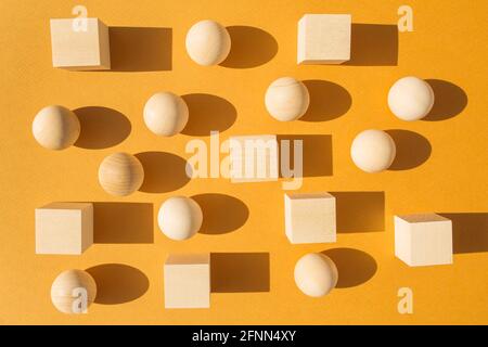 Many wooden cubes and balls on orange background. Stock Photo