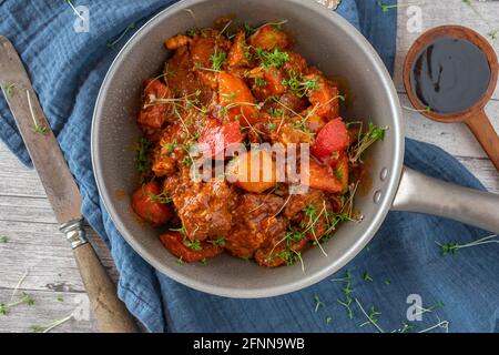 filipino spicy Pork stew afritada with vegetables served in bowl. Overhead view Stock Photo