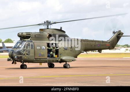 Royal Air Force, RAF, Puma HC.1 helicopter XW235 taxiing at Royal International Air Tattoo, RIAT, RAF Fairford, UK. Crewman observing for safety Stock Photo