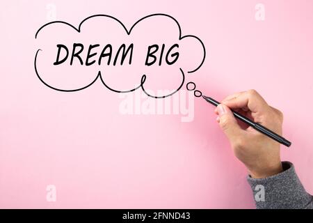 Hand writing Dream Big in cloud bubble on pink background Stock Photo