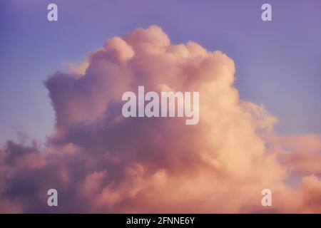 A large white cloud against a warm blue sunset sky Stock Photo