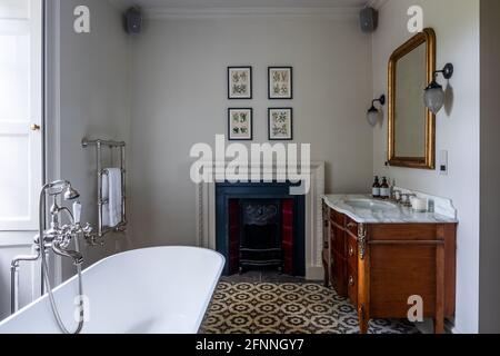 Antique wash stand and fireplace with bath in restored Jacobean Wool Merchant's house, Somerset. Stock Photo