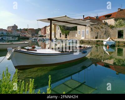 Fisherman boat on the Canal in the harbor of Vrboska village, Hvar island, Croatia Stock Photo