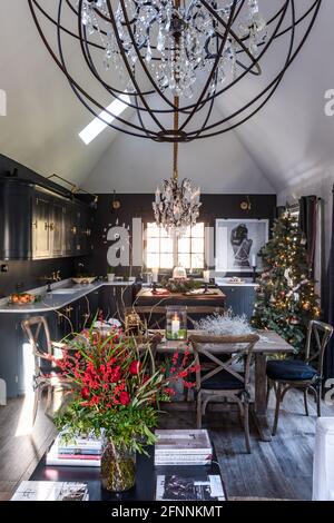 Open plan kitchen with chandeliers and Christmas tree in Georgian cottage, West Sussex. Stock Photo