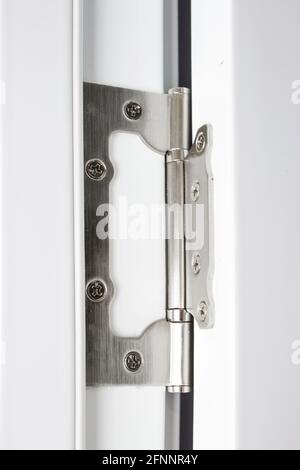 Stainless door hinges on a white door. Hinges on the white door. Stock Photo