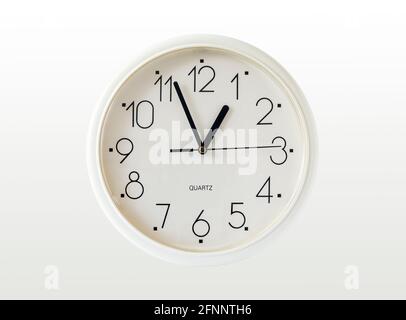 A generic white plastic quartz-action wall clock isolated on a white background Stock Photo