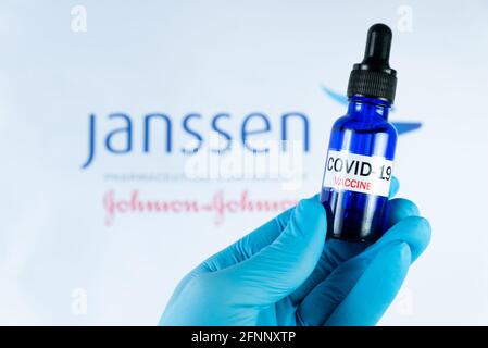 A hand holds a vial in front of Janssen vaccine logo in Barcelona Spain, on May 18, 2021. Janssen is Covid-19 vaccine produced by the pharmaceutical c Stock Photo