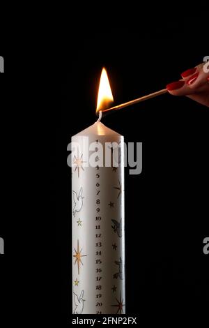Woman lighting a christmas advent candle.  France. Stock Photo