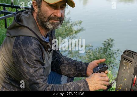 Man fishing while sitting on pontoon boat in lake Stock Photo - Alamy