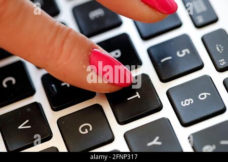 Closeup of hand of a business woman typing on a laptop.  France. Stock Photo