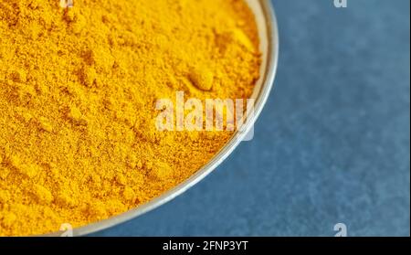 Close up picture of turmeric powder in a bowl, shallow depth of field, space for text. Stock Photo