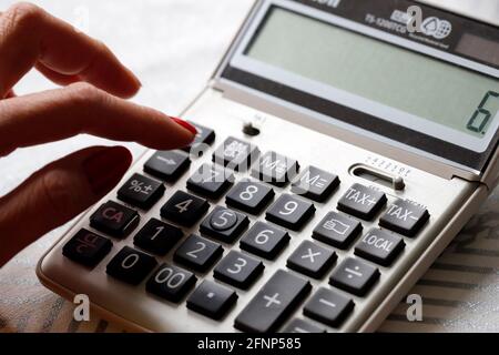 Close-up of woman using calculator.  France. Stock Photo