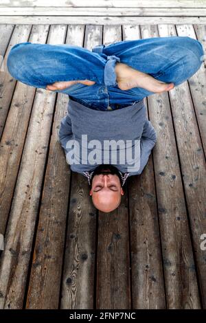 Man doing yoga in Marceddi, Sardinia, Italy Stock Photo