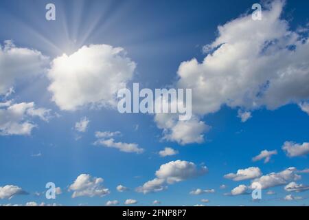 cloudy blue sky background with sun rays Stock Photo