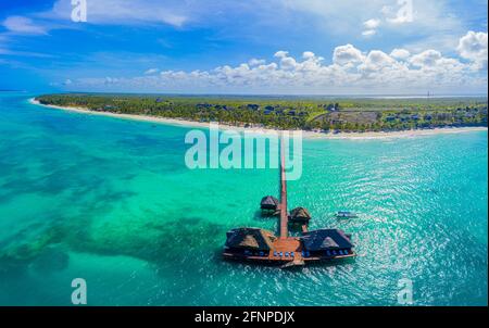 Aerial shot of the Stilt hut with palm thatch roof washed with turquoise Indian ocean waves on the white sand sandbank beach on Zanzibar island, Tanza Stock Photo