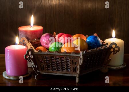Painted Easter eggs and candles, multicolored, vintage, on a wood table Stock Photo