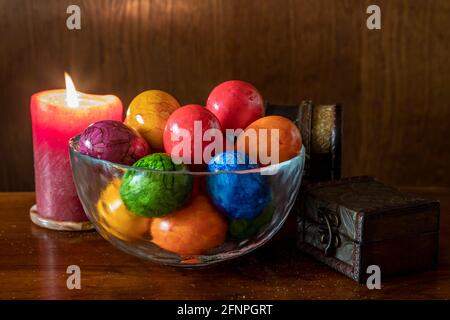 Painted Easter eggs and candles, multicolored, vintage, on a wood table Stock Photo
