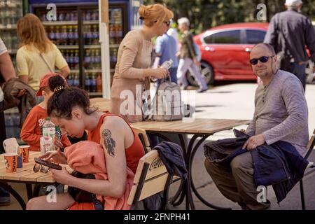 Kyiv, Ukraine - May 16: Opening of street cafes after quarantine. People relaxing on the terrace in sunny weather on Sunday. High quality photo Stock Photo