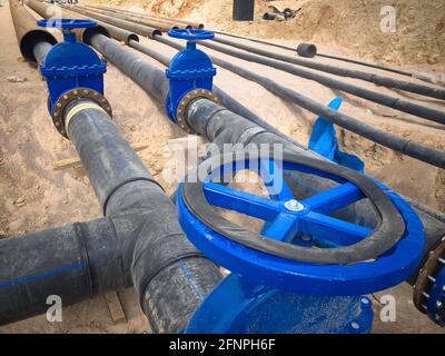 Valves on pipeline in ground. Pipe valves in trench Stock Photo